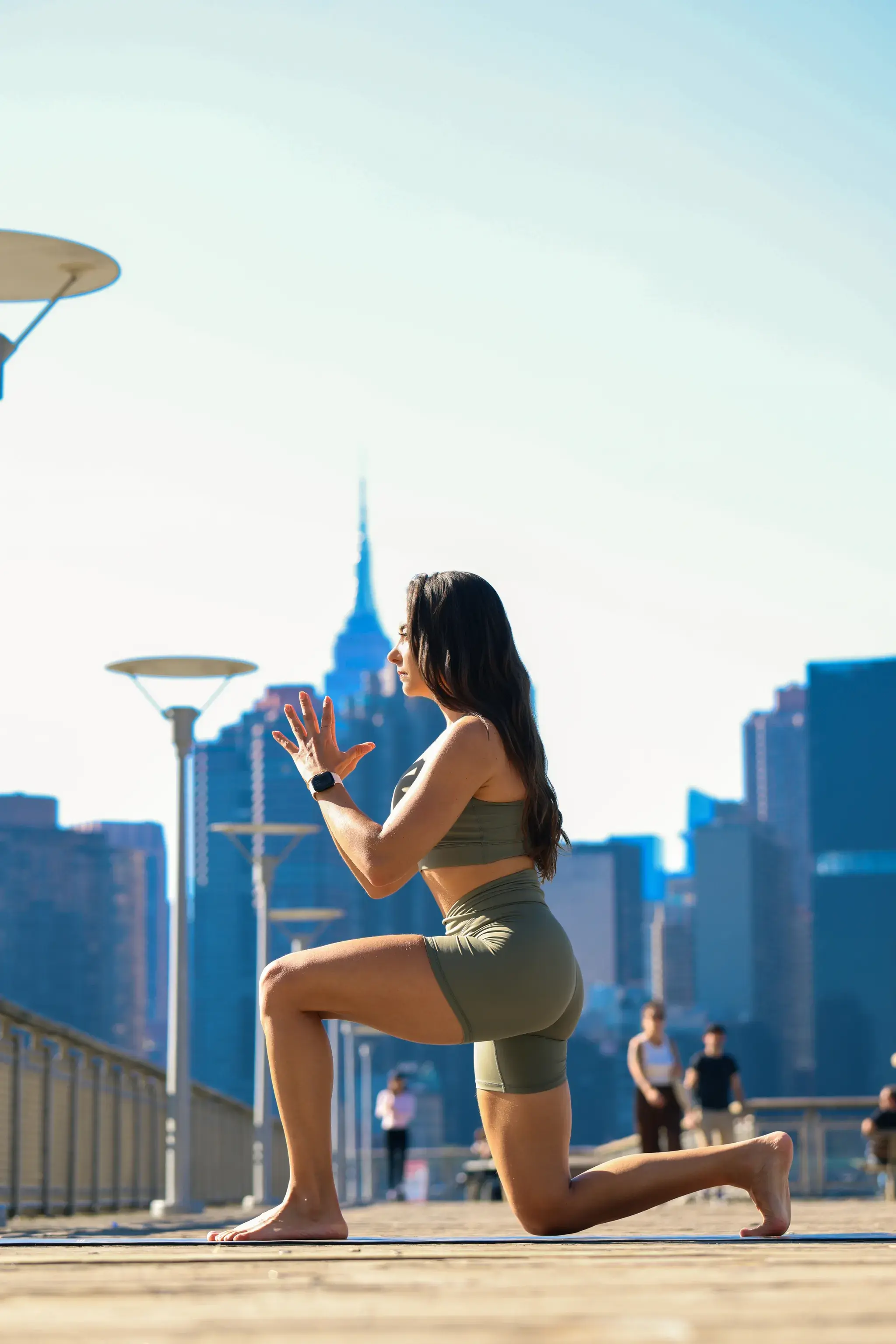 Hayane doing a yoga pose outside in a big city.